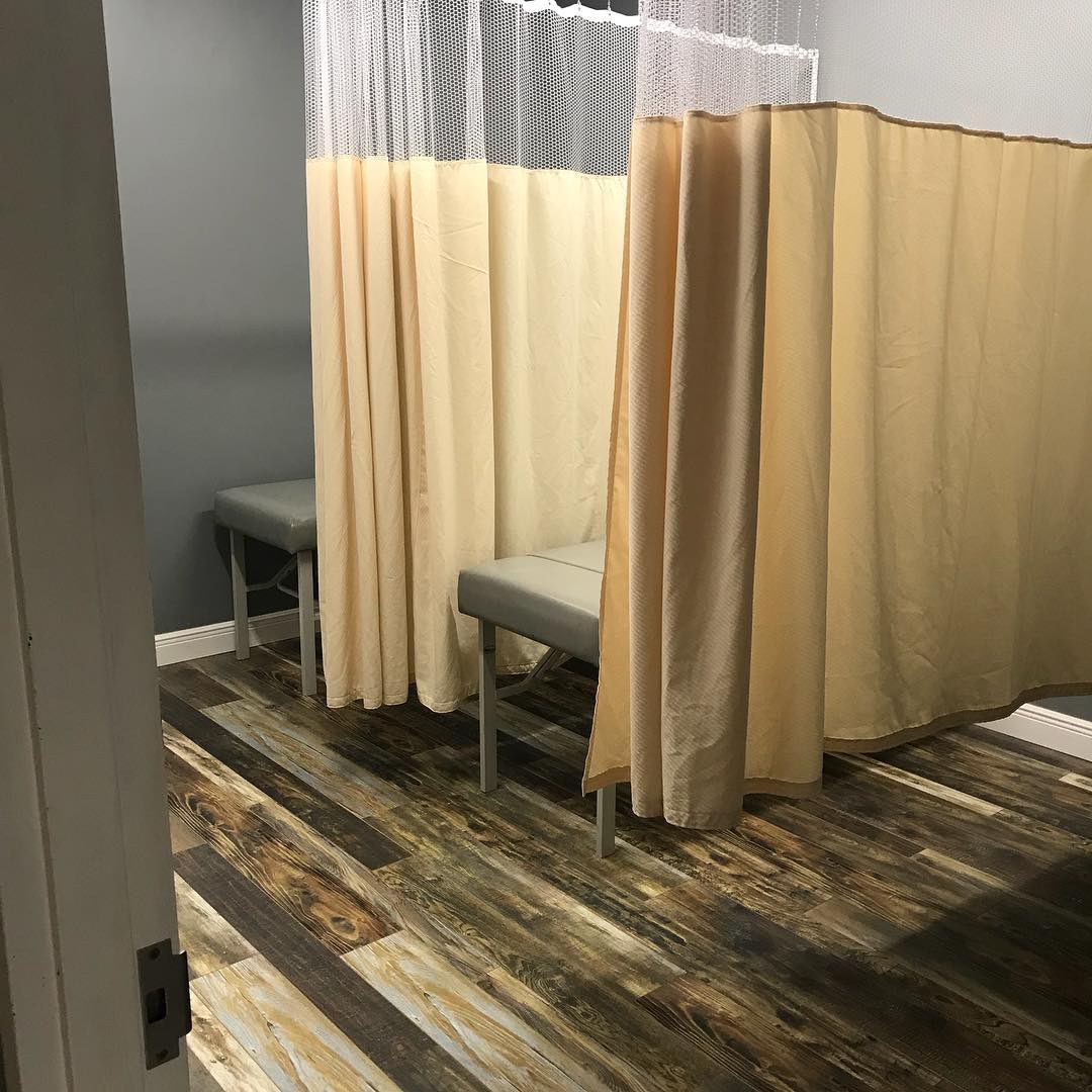 Private treatment bay with curtains and therapy table at the Miami Gardens office